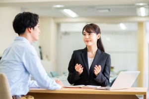 英語の日本人講師女性と楽しく会話する男性